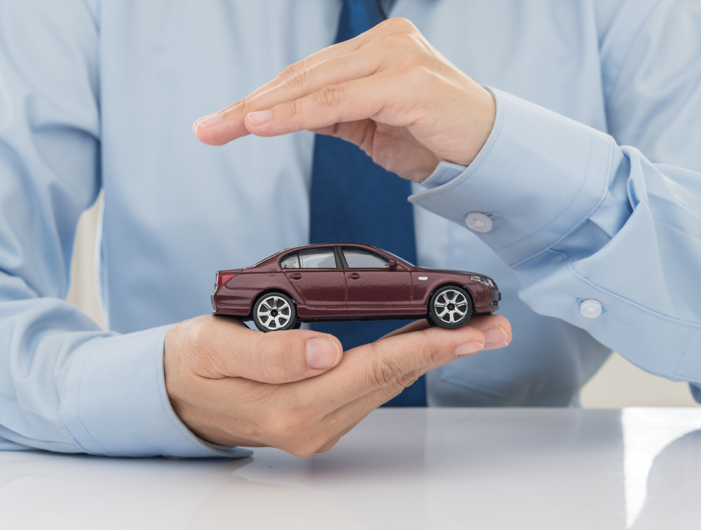 Man holding a car ready to face automobile Insurance Dispute
